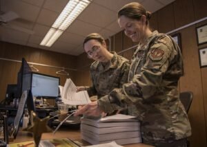 Military legal office staff reviewing case files and documents