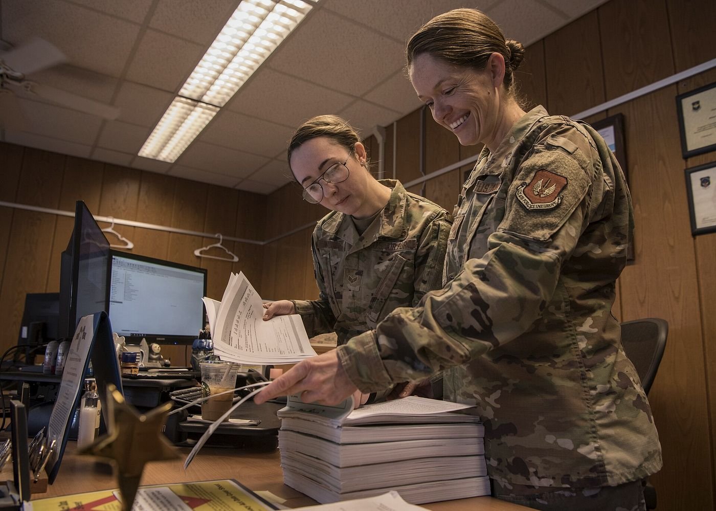 Military legal office staff reviewing case files and documents